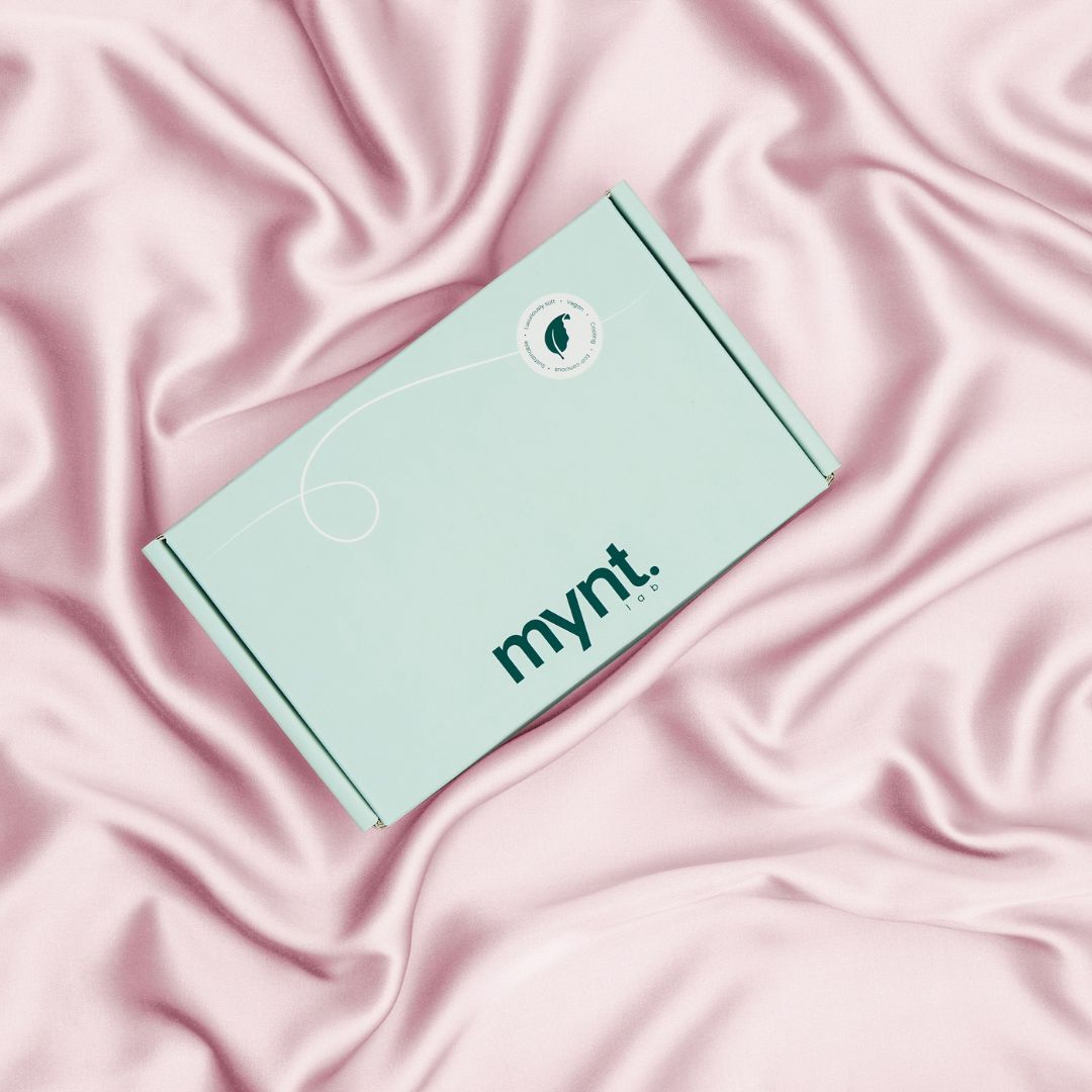 Mynt Lab packaging box on blush pink silky bedding