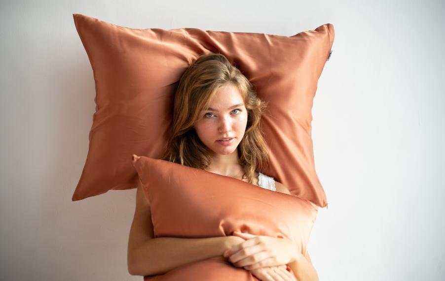 Sleep-Skin Connection showing woman resting on terracotta bedding for skin and hair comfort