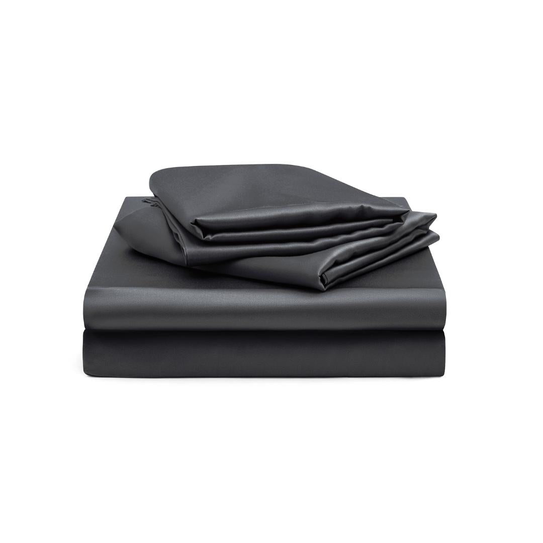 The Fitted Sheet Set (3-Piece) in charcoal features silky soft, neatly folded sheets - fitted sheet, flat sheet, and pillowcases - stacked on a white background.