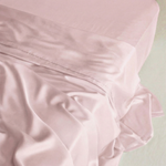 Soft pink MyntBalance™ TENCEL™ lyocell flat sheet, lightweight and breathable, draped on a bed.