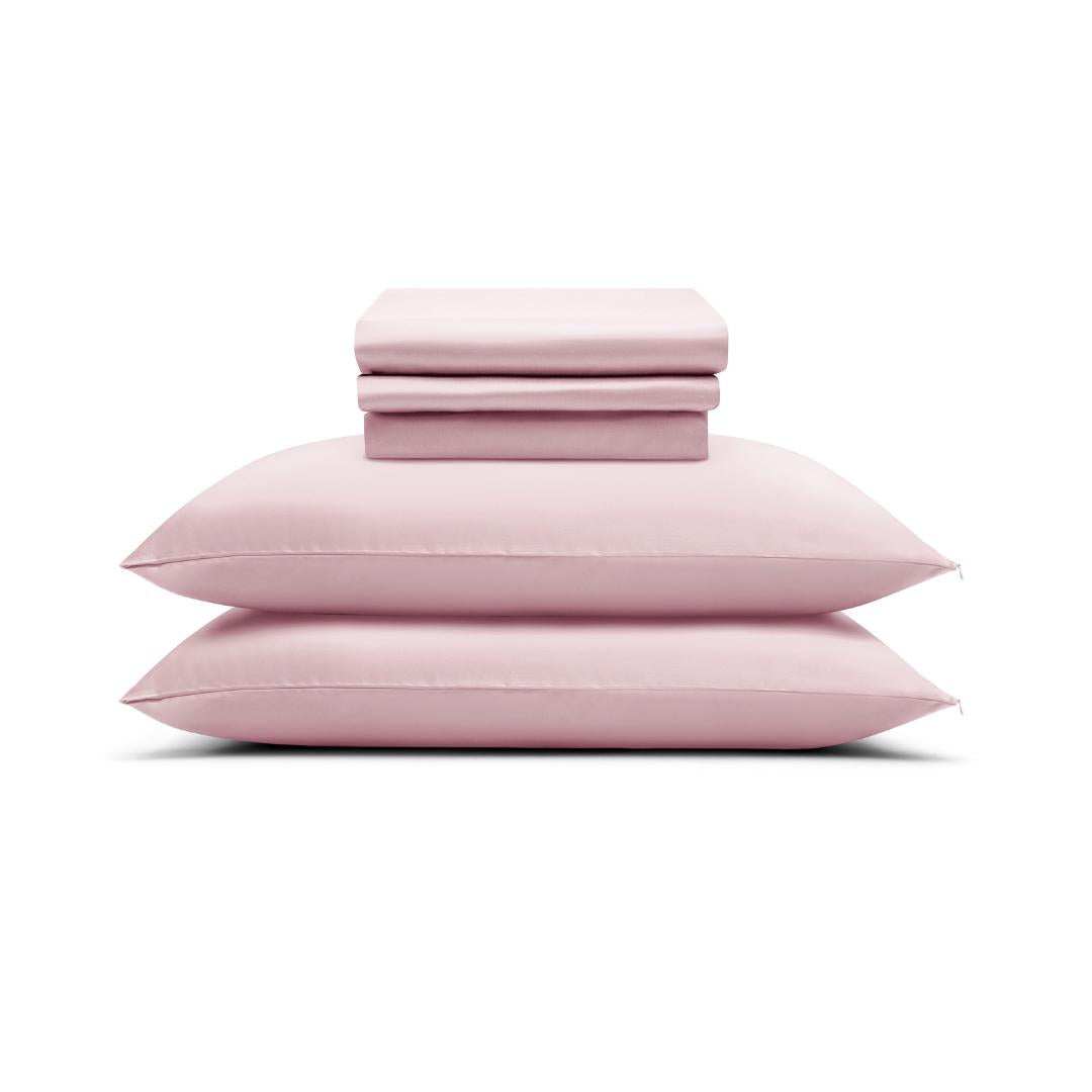 The MyntFusion™ Complete Sheet Set (4-Piece) by Mynt Lab, shown in light pink with pillowcases and sheets neatly stacked on a white background, is perfect for hot sleepers.
