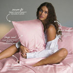 A woman with long brown hair sits on a bed holding the MyntFusion™ Pillowcase by Mynt Lab. This silky-smooth, king-size pillowcase offers a secure fit, stays cool, features antibacterial fibers, is skin-friendly, and controls frizz.