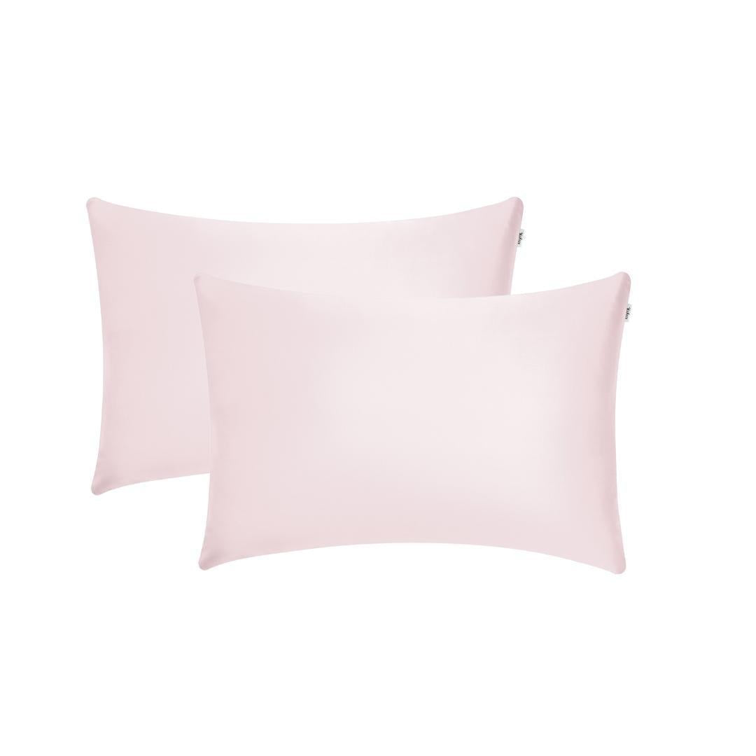 Two light pink rectangular Pillowcases are shown overlapping on a white background, ideal for beauty sleep and waking up with hydrated skin.