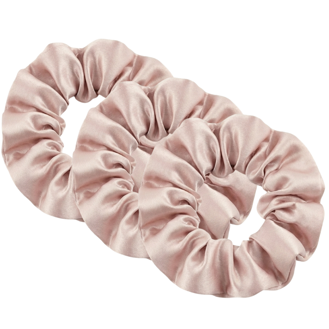 Three light pink MyntFusion™ Scrunchies by Mynt Lab are displayed side by side on a white background. These satin scrunchies are gentle on hair, minimize breakage, and add an elegant touch to your style.