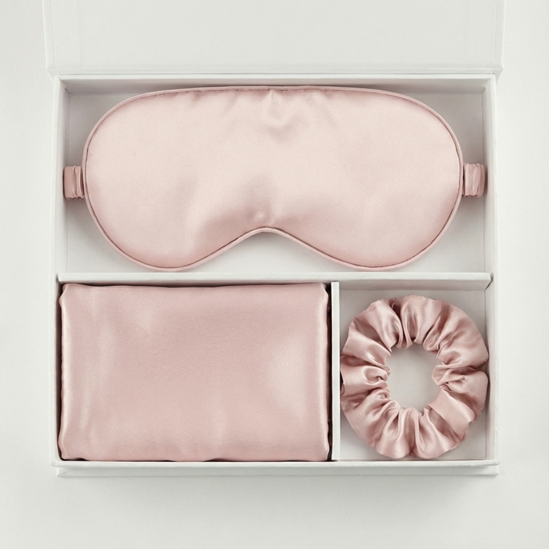 The Beauty Sleep Gift Set comes in a white box with a pink silky sleep mask, pillowcase, and scrunchie, each arranged in its own compartment for the ultimate beauty sleep experience.