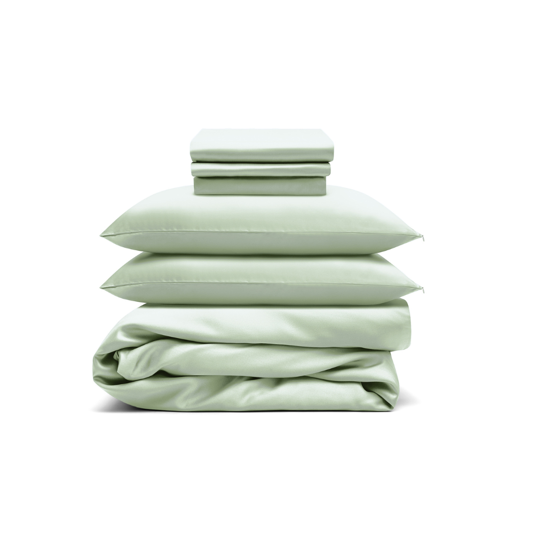 The Bedding Bundle features a neatly stacked set of light green cooling bedding, including two folded pillowcases, two pillows, and a folded duvet cover, all arranged against a white background.