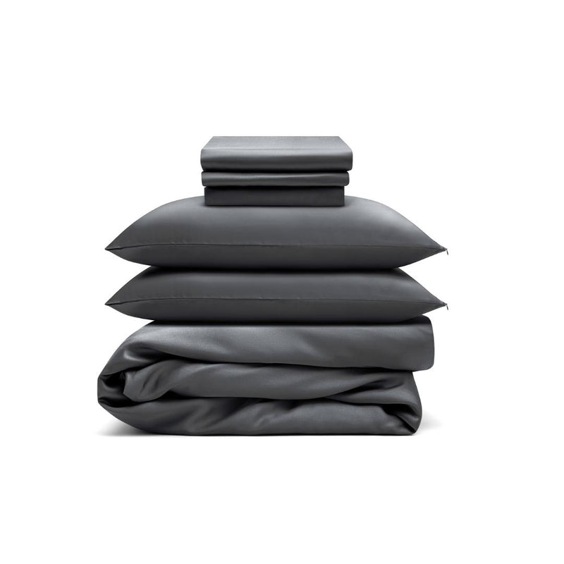 A Bedding Bundle in charcoal, featuring two pillowcases, a folded sheet, and a folded duvet cover, neatly stacked against a white background.
