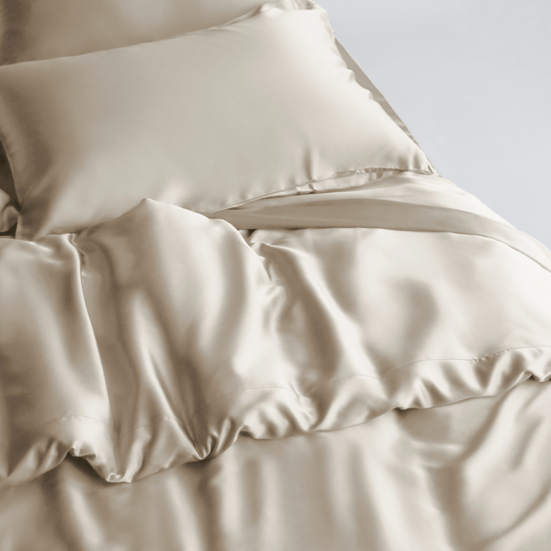 A bed dressed in smooth, sand silky sheets and a matching pillowcase is topped with the Duvet Cover - sustainably made for gentle folds and a soft, luxurious finish.