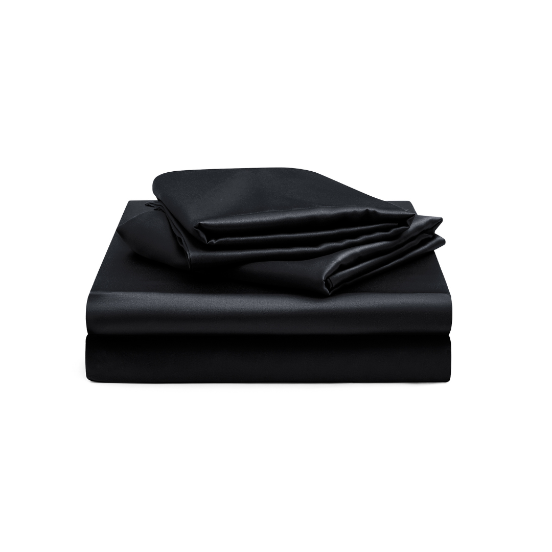 A Black Fitted Sheet Set, featuring silky soft black bed sheets with a flat sheet, fitted sheet, and pillowcases, is neatly folded and stacked against a white background.