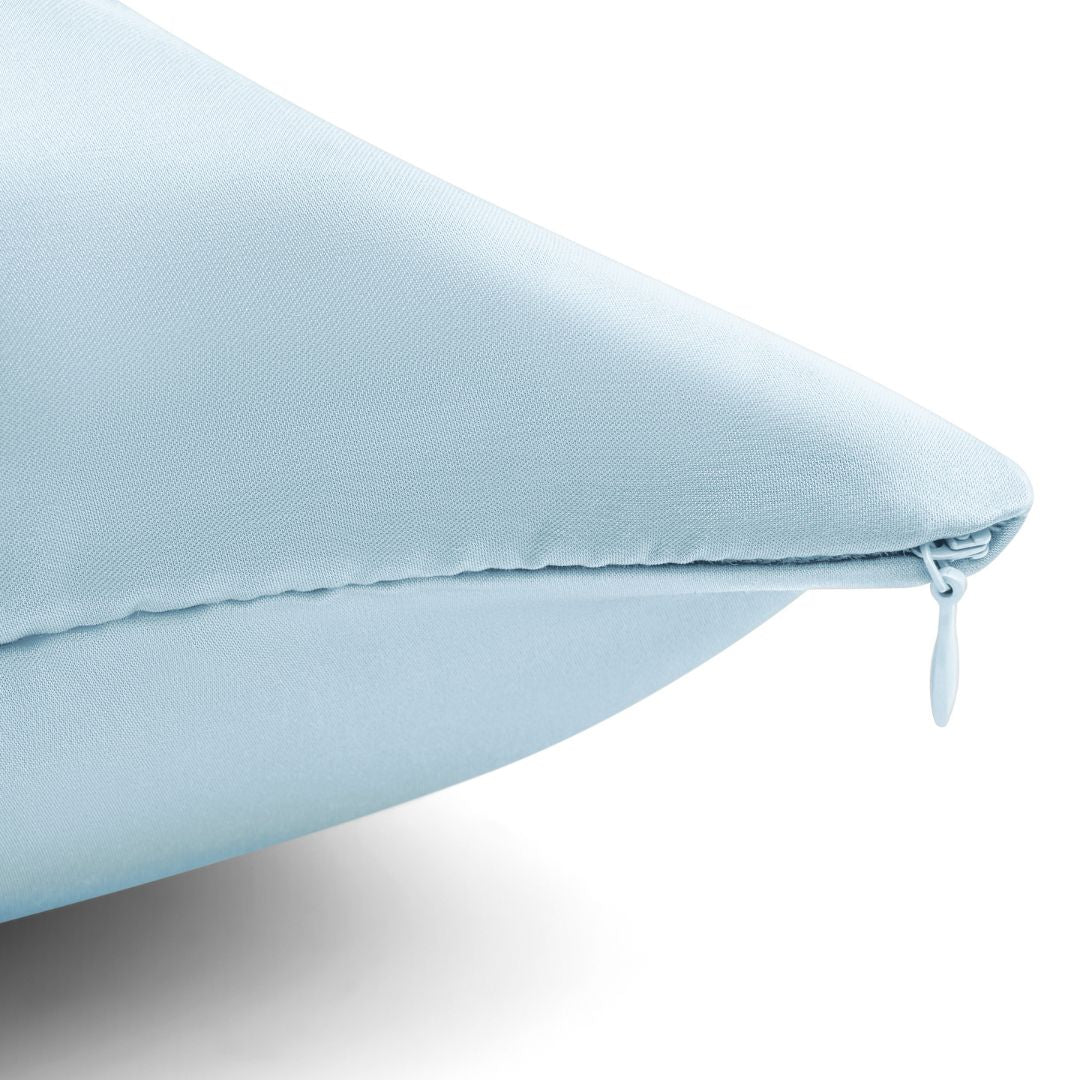 Close-up of light blue vegan silk pillowcase with hidden zipper detail, showcasing smooth texture and premium finish