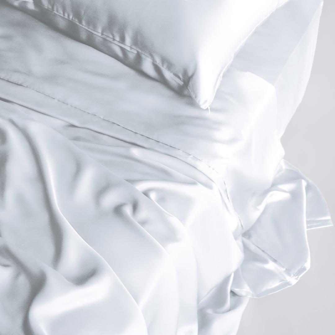 A close-up of a bed featuring the Mynt Lab MyntFusion™ Complete Sheet Set (4-Piece) with silky-soft sheets and a matching pillowcase, creating a luxurious and elegant look.