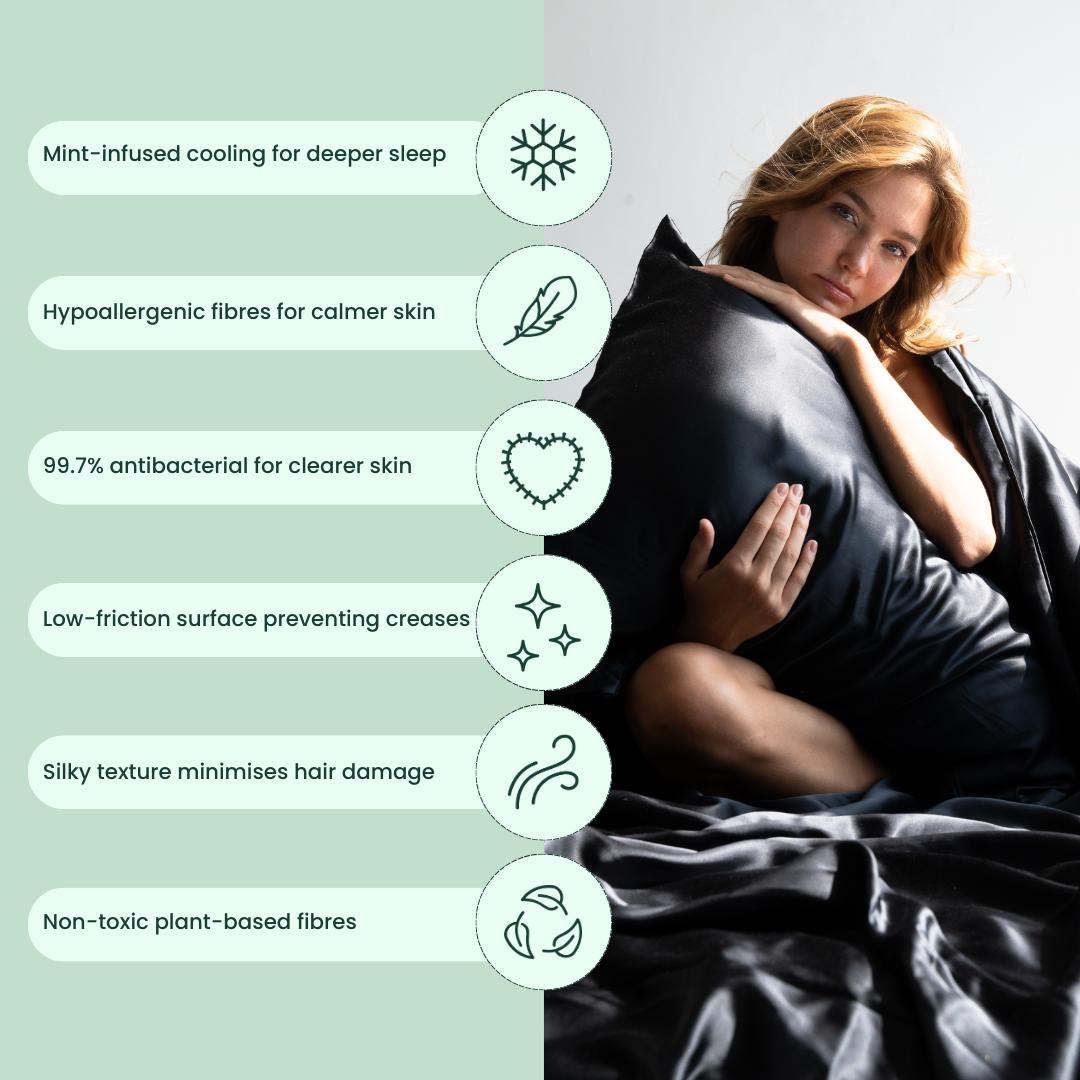 A woman sits on a bed with the mynt lab black pillowcase and matching sheets. Icons highlight cooling, hypoallergenic, antibacterial, low-friction fibres, and a cooling pillowcase for essentials to achieve deep sleep.