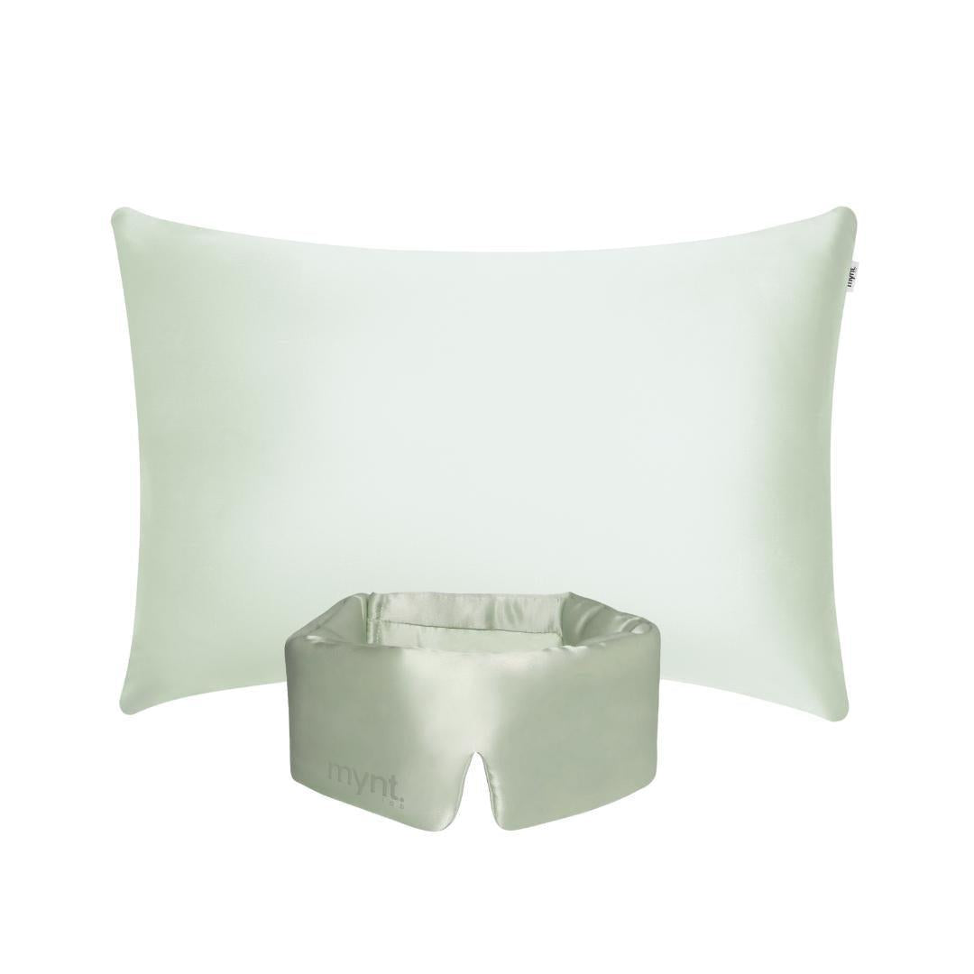 The Deep Sleep Bundle features a light green rectangular pillow with a cooling pillowcase placed behind a matching light green silky blackout sleep mask, which has an opening at the bottom and "mynt lab." printed on it, set against a white background.