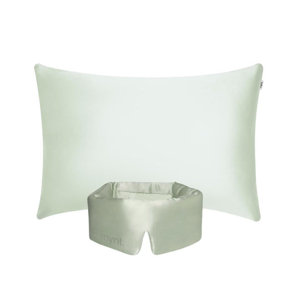 The Deep Sleep Bundle features a light green rectangular pillow with a cooling pillowcase placed behind a matching light green silky blackout sleep mask, which has an opening at the bottom and "mynt lab." printed on it, set against a white background.