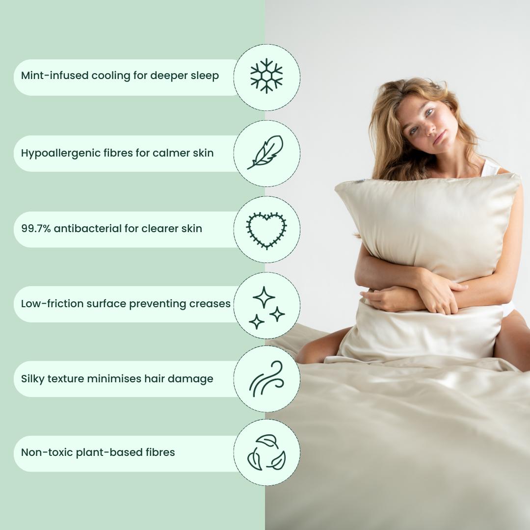 A woman sits on a bed holding the Deep Sleep Bundle pillowcase, with icons showing its mint-infused cooling, hypoallergenic and antibacterial features, silky plant-based fibres, and non-toxic materials - ideal for deep sleep.