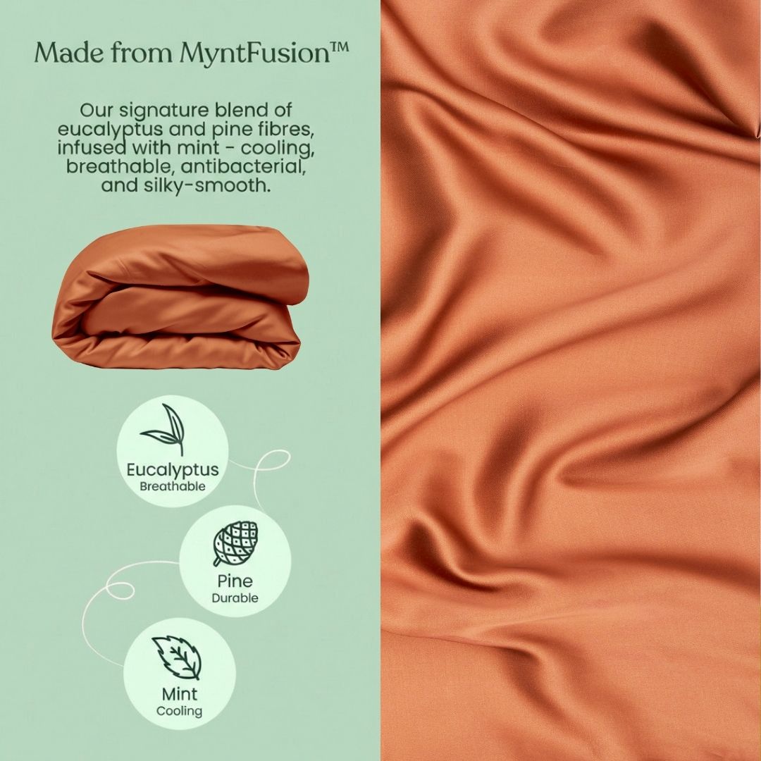 A terracotta MyntFusion™ Duvet Cover  by Mynt Lab lies folded on green beside a fabric close-up. Icons show eucalyptus (breathable), pine (durable), and mint (cooling) benefits - perfect for hot sleepers.