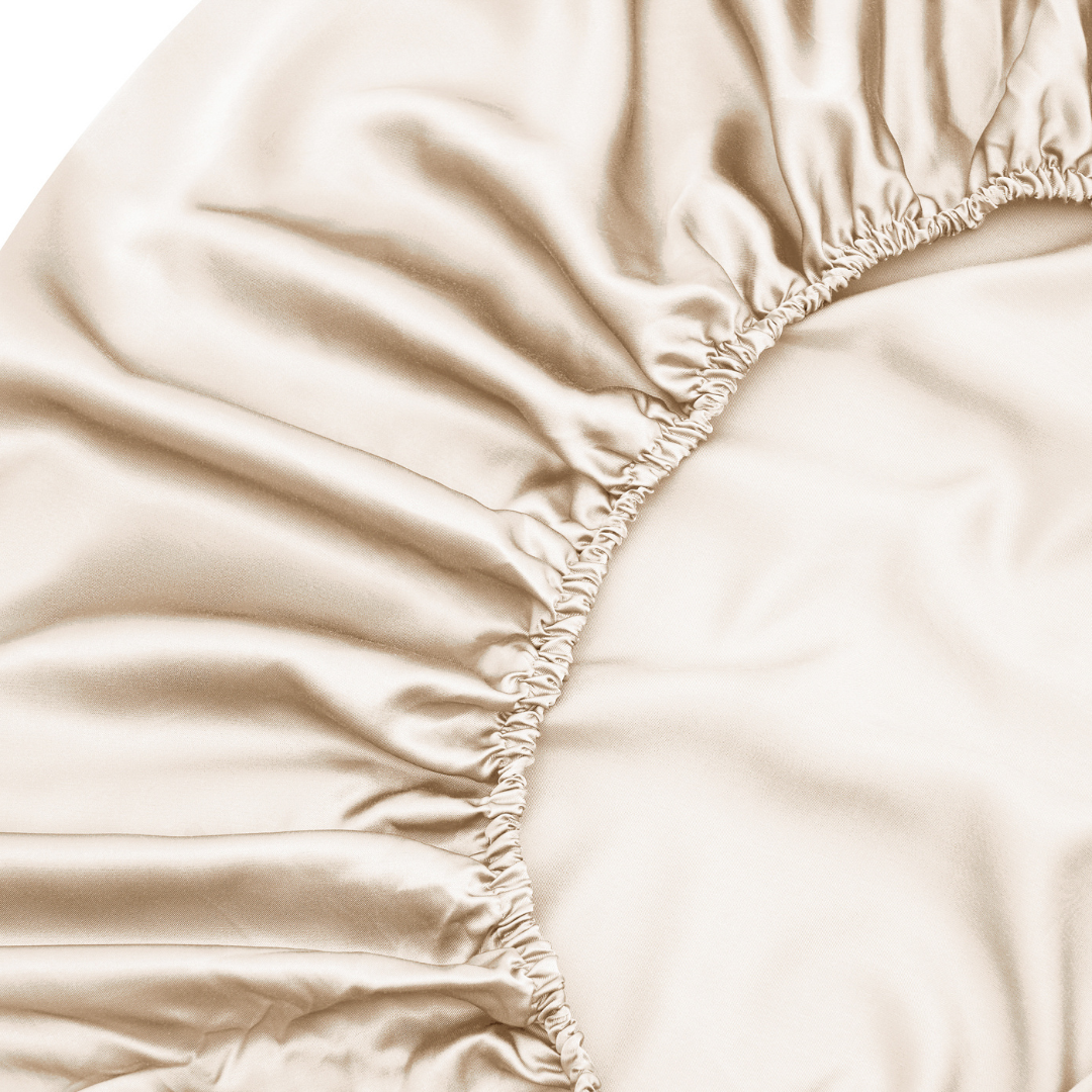 Close-up of the Fitted Sheet Set (3-Piece) in beige satin, highlighting its smooth, shiny fabric and elastic edge—ideal for those seeking silky soft sheets with a luxurious touch.