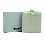 A light green Mynt Lab box stands next to a matching drawstring bag, both sleek and minimalist—ideal for gifting the MyntFusion™ Complete Sheet Set (4-Piece) to elevate any bedroom.