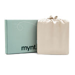A pale green mynt lab box stands beside a sand silky drawstring bag against a white background - the perfect presentation for the Fitted Sheet Set (3-Piece).