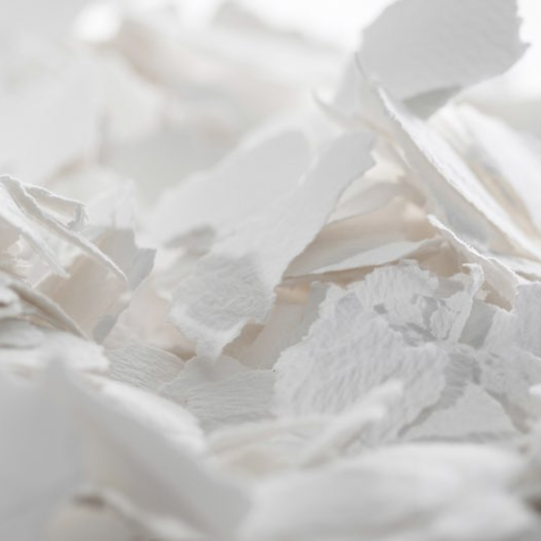 Close-up of torn and crumpled pieces of white paper, creating a textured and layered abstract background.