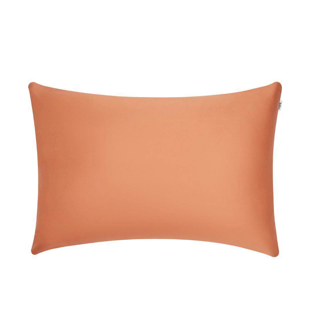 A rectangular, smooth, orange pillow with slightly pointed corners, set against a plain white background.