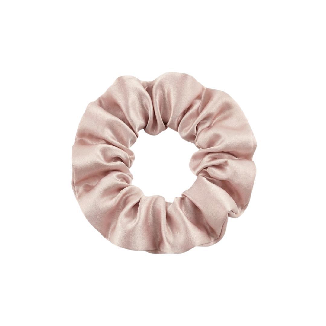 The MyntFusion™ Scrunchie features a light pink, silky fabric with a smooth texture, displayed in a circular shape on a plain white background.