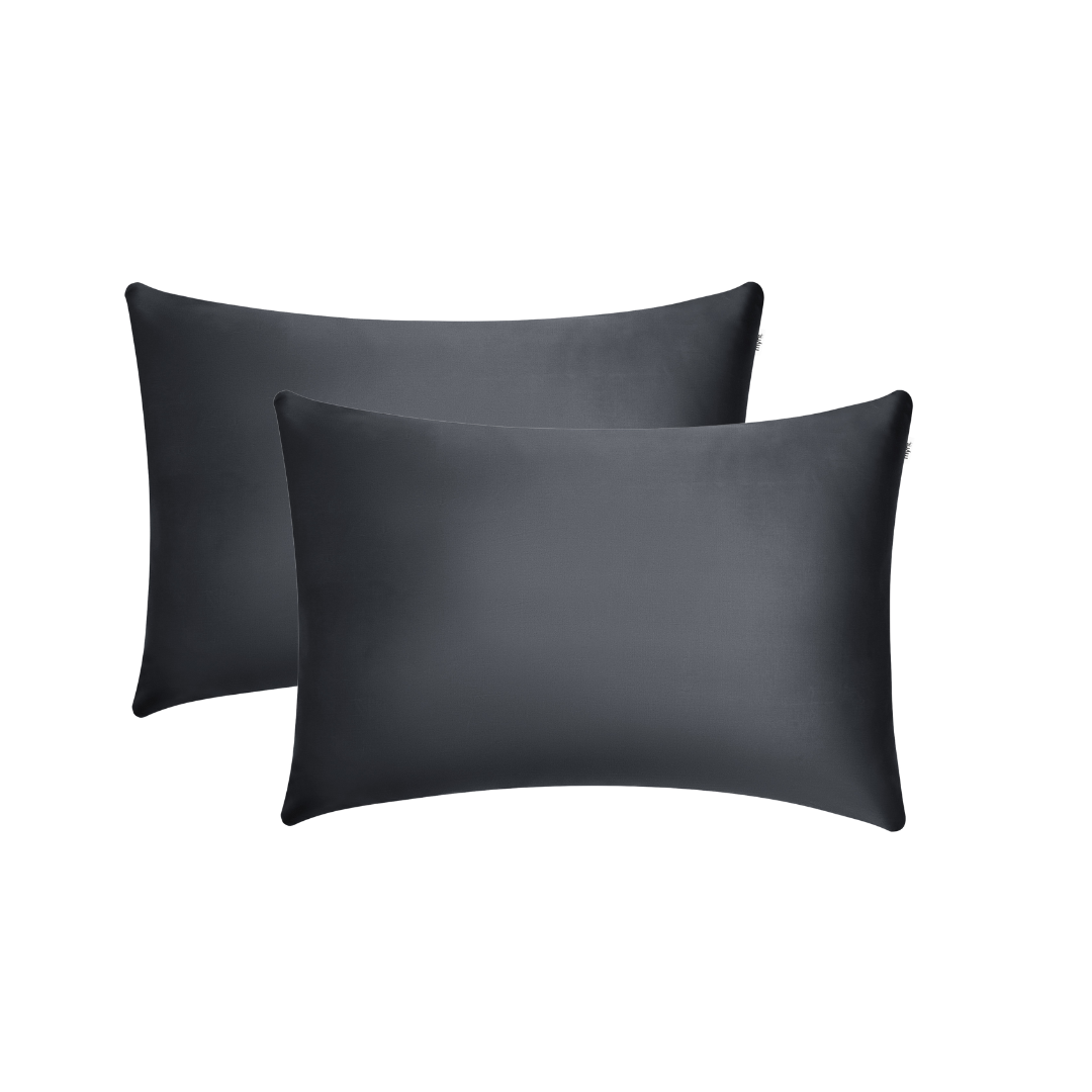 Two black pillowcases are stacked slightly offset against a plain white background, offering a sleek look that enhances beauty sleep and helps reduce frizz.