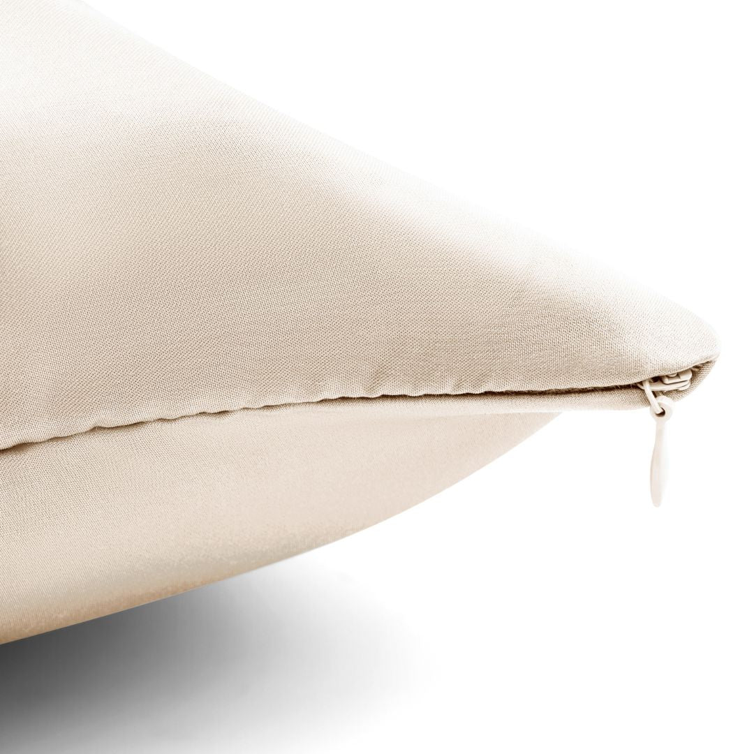 Close-up of a sand Mynt Lab Pillowcase corner with a visible zipper on a white background. This silky fabric looks smooth and shiny, helps reduce frizz, and supports hydrated skin for your best beauty sleep.