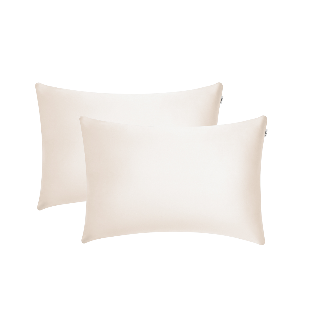 Two sand-coloured rectangular pillowcases with a smooth, silky texture are shown overlapping on a white background - ideal for beauty sleep and reducing frizz.