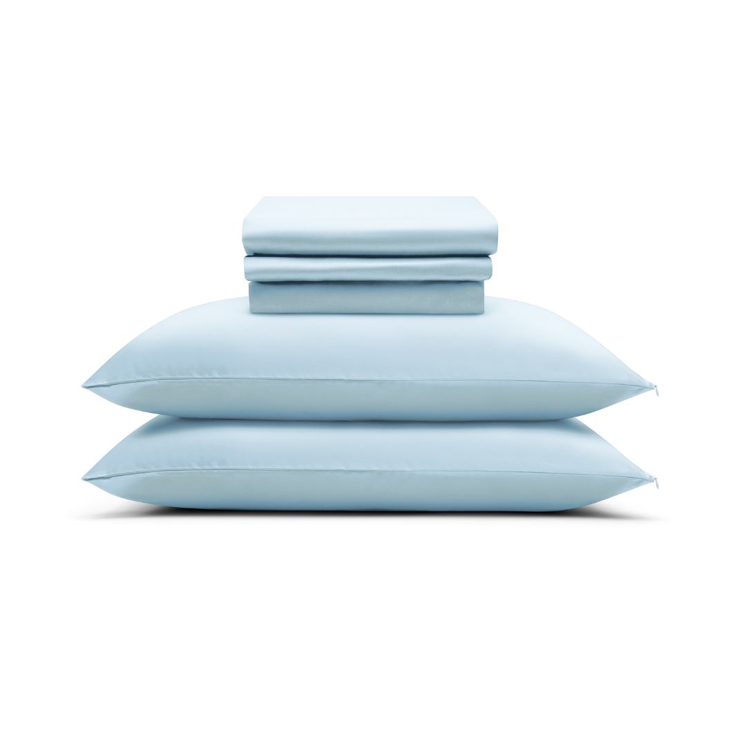 A neatly folded Powder Blue Sheet Set rests atop two matching pillows, all set against a white background.