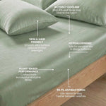 A close-up of a neatly made bed with green sheets and pillows, featuring text highlighting benefits: actively cooling, skin and hair friendly, hypoallergenic, plant-based performance, and 99.7% antibacterial.