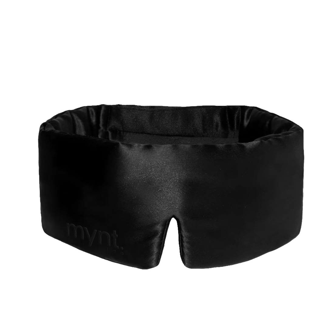 The Sleep Mask is a black, wide, padded mask with a bottom-centre cut-out and "mynt lan" subtly embossed on the left side, designed to block light and help you achieve deep sleep.