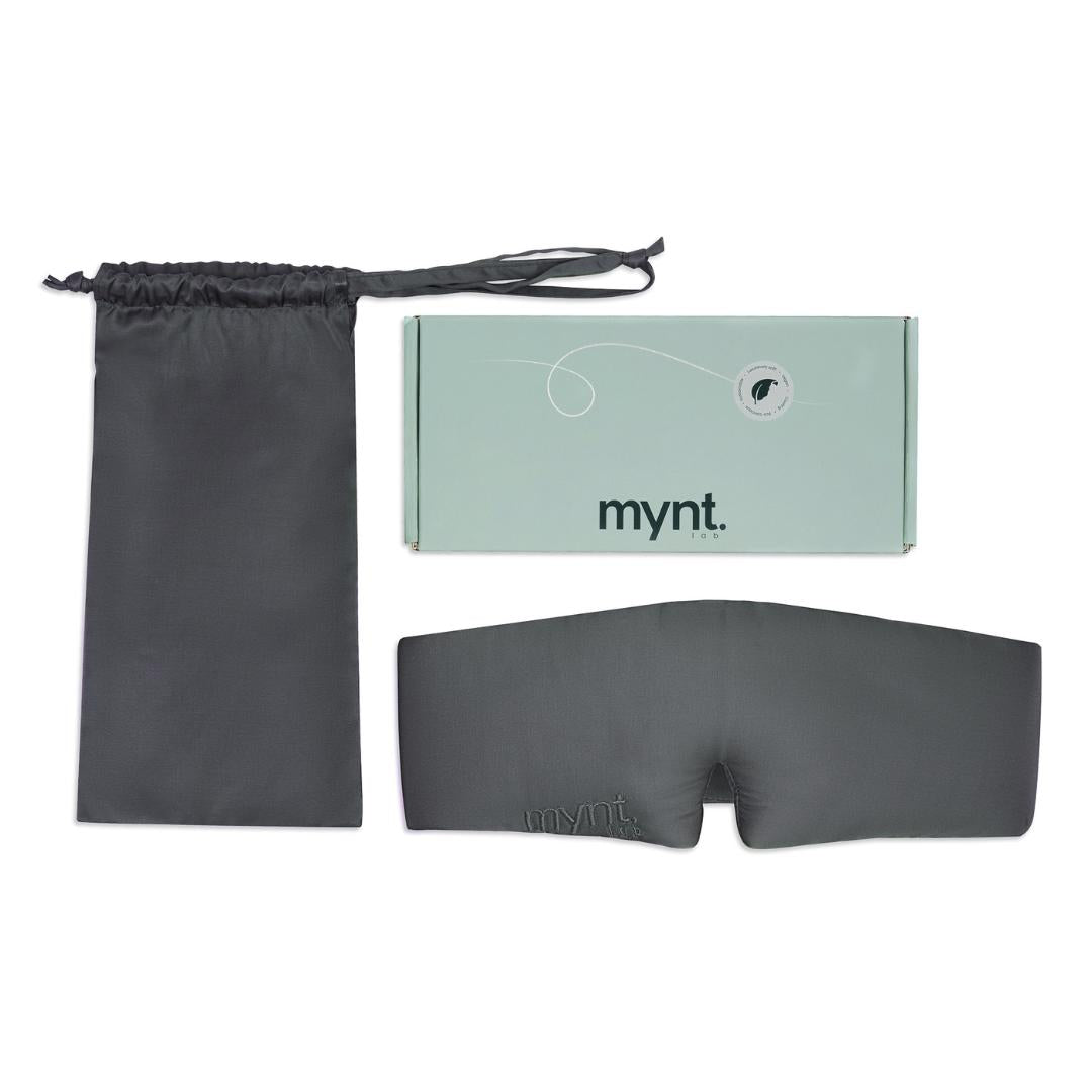 The Sleep Mask, in charcoal comes with a matching drawstring pouch and is packaged in a light green mynt lab branded box, all displayed on a white background - ideal for deep sleep.