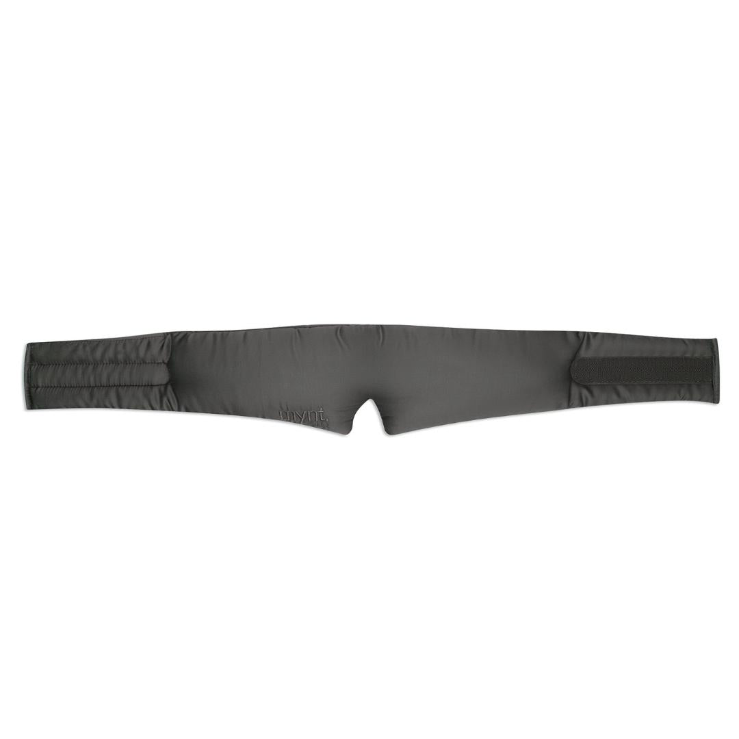 The Sleep Mask features a charcoal, padded, and slightly quilted strap with Velcro fasteners on both ends. Designed to block light for deep sleep, it has subtle stitching and a small embroidered logo for a soft, comfortable fit.