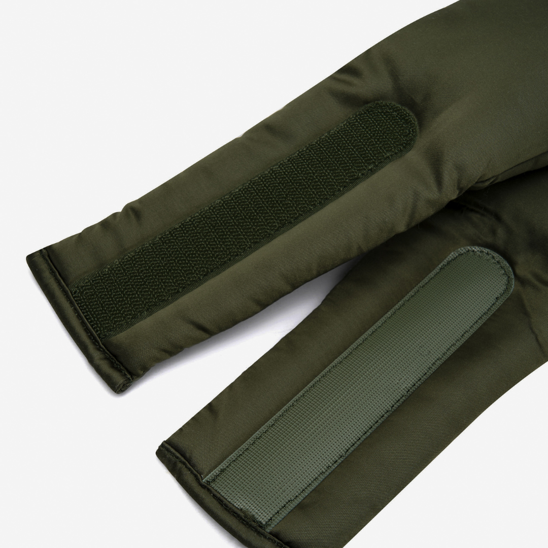 Close-up of two olive green padded sleeves with rectangular Velcro strips from the Sleep Mask, designed to block light, shown on a white background.