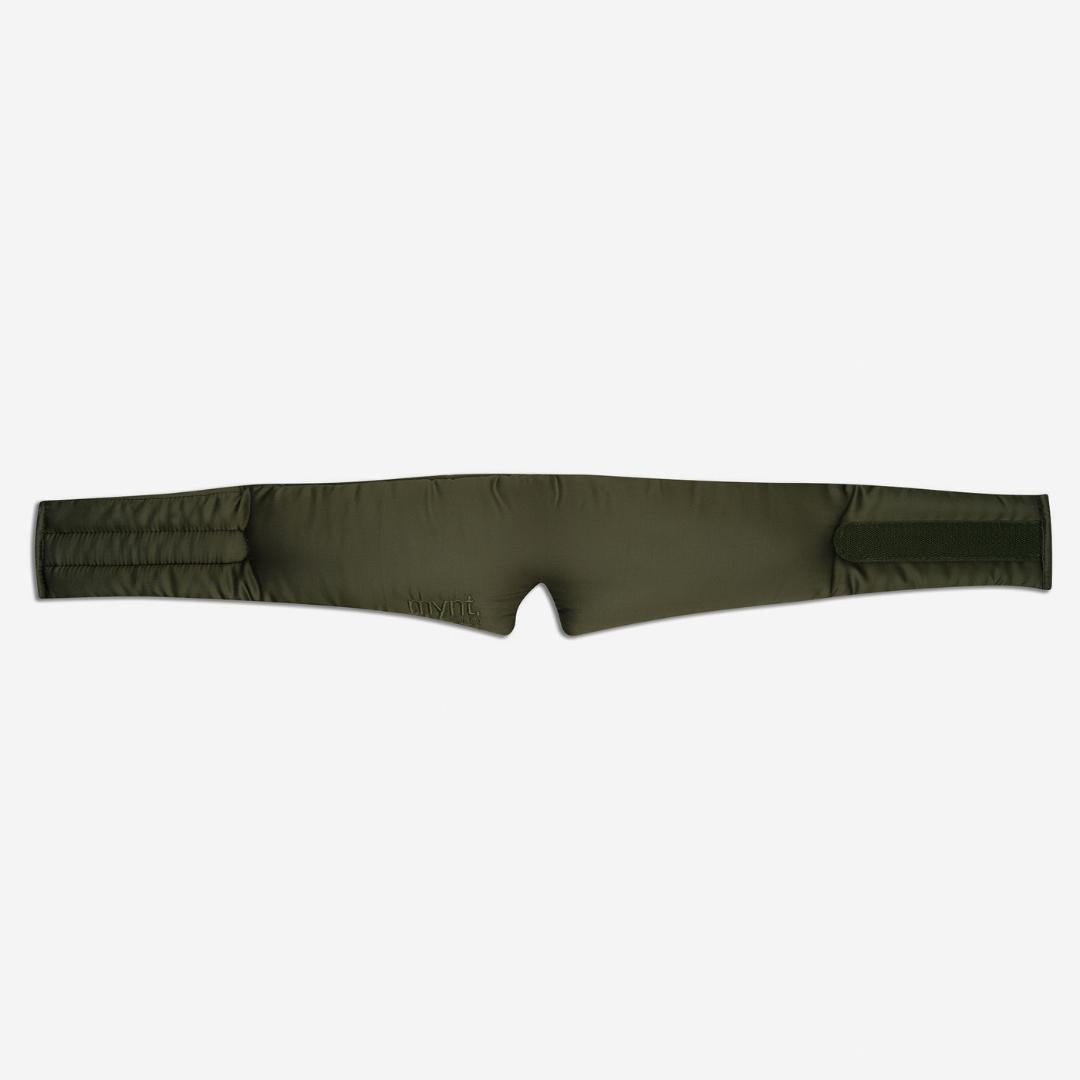 The Sleep Mask, in padded olive-green, features two wide straps and a centre notch for maximum light blocking and deep sleep support, shown laid flat on a white background.