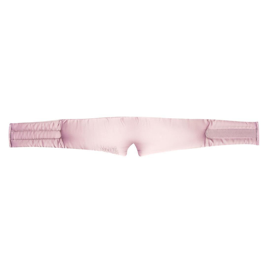 The Sleep Mask is a light pink and padded with two adjustable Velcro straps on each end, designed to block light and promote deep sleep. It is shown laid flat on a white background.