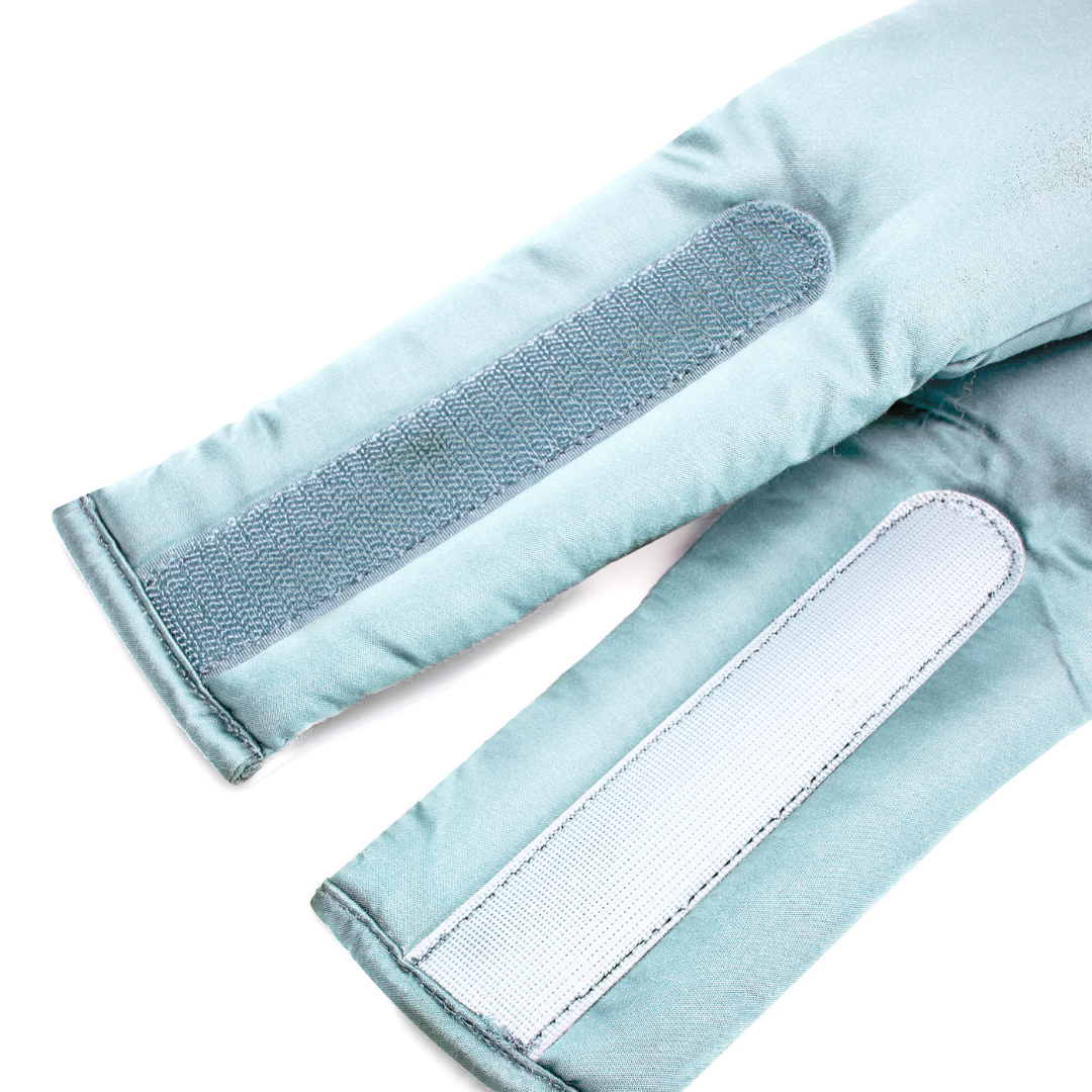 Close-up of two light blue padded straps with long rectangular Velcro patches from the Sleep Mask, designed to block light and promote deep sleep, shown on a white background.