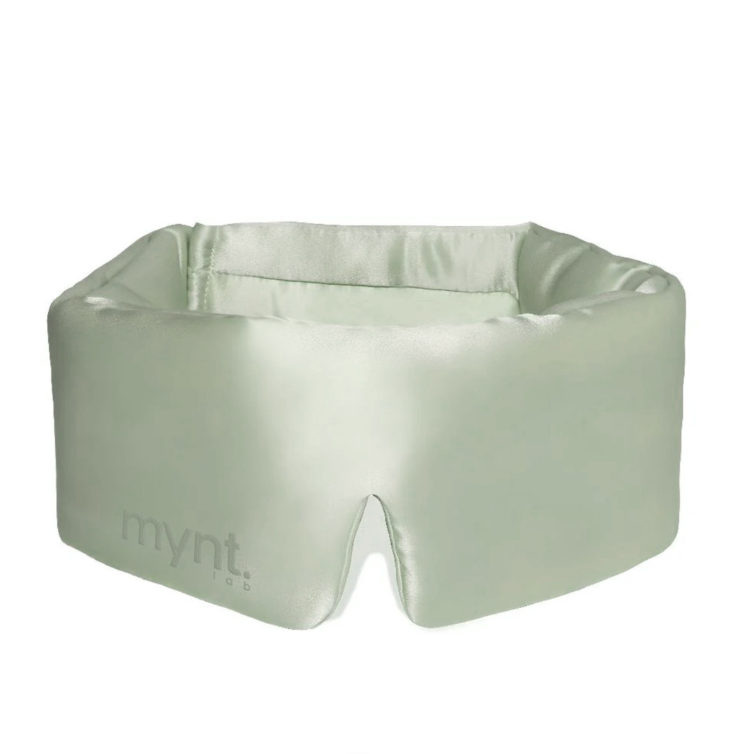 The Sleep Mask by mynt lab is light green and silky, it fully covers the eyes to block light for deep sleep, and features a bottom notch for the nose plus smooth, padded fabric for extra comfort.