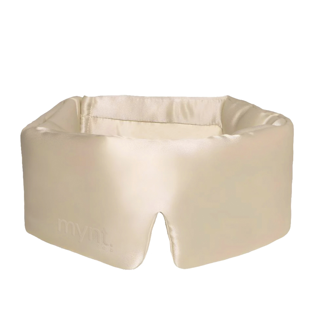 The Sleep Mask is a soft, light beige silky mask designed to block light for deeper sleep, featuring a subtle mynt lab logo on the side and a nose cutout for a comfortable, secure fit.