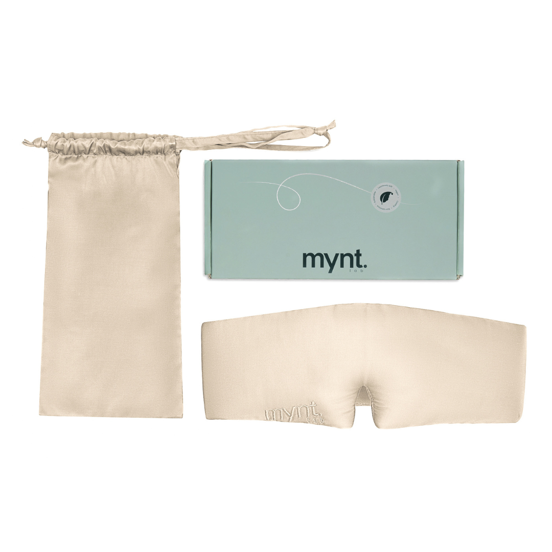 The Sleep Mask in sand, featuring the mynt lab logo, blocks light for deep sleep. It includes a matching drawstring pouch and a light green mynt lab box, all shown on a white background.