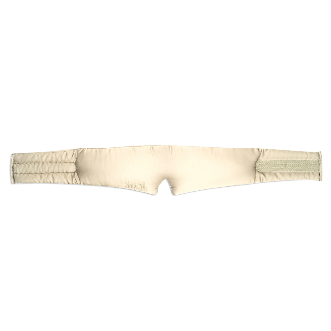 The Sleep Mask is a beige, padded fabric headband with Velcro fasteners, designed to wrap around the head for blocking light and promoting deep sleep.