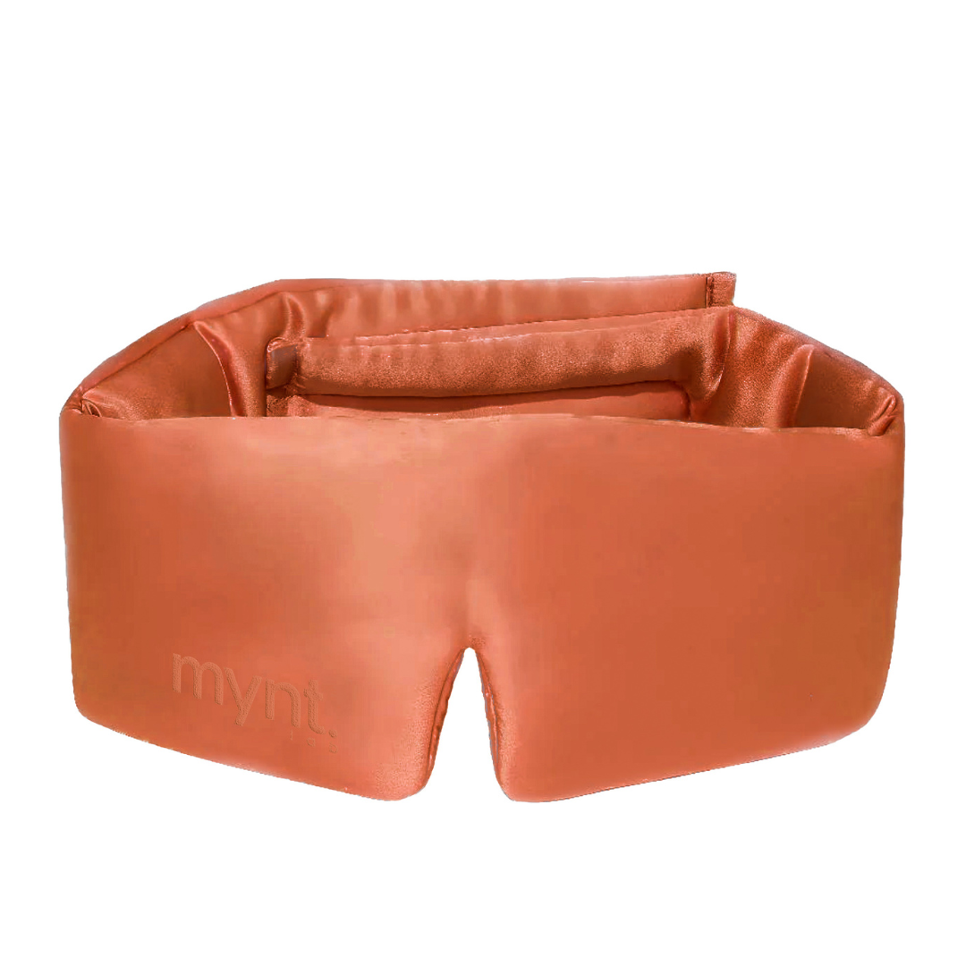 The Sleep Mask is a soft, padded terracotta mask embossed with "mynt lab" on the side, designed to block light and provide comfort and relaxation for deep sleep.