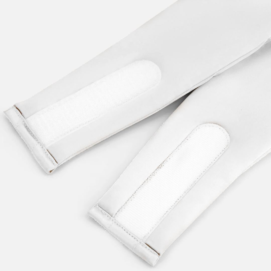 Close-up of two white Velcro straps attached to the Sleep Mask on a light surface, highlighting stitched and textured fasteners designed to effectively block light and promote deep sleep.