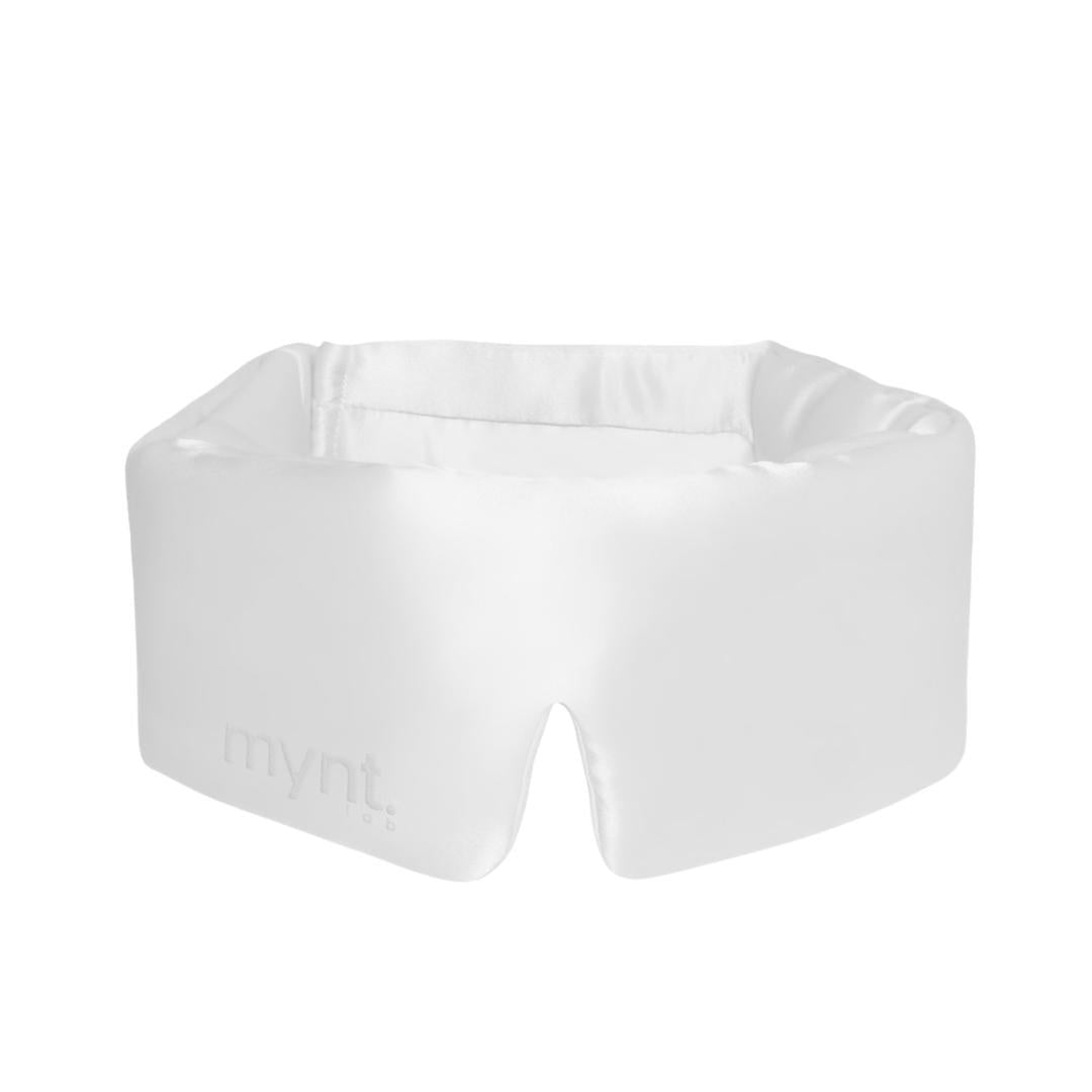 The Sleep Mask is a white, padded mask with a subtle mynt lab logo, designed to fit comfortably around the eyes and nose. Its slight sheen and secure fit help block light, making it ideal for deep sleep and relaxation.